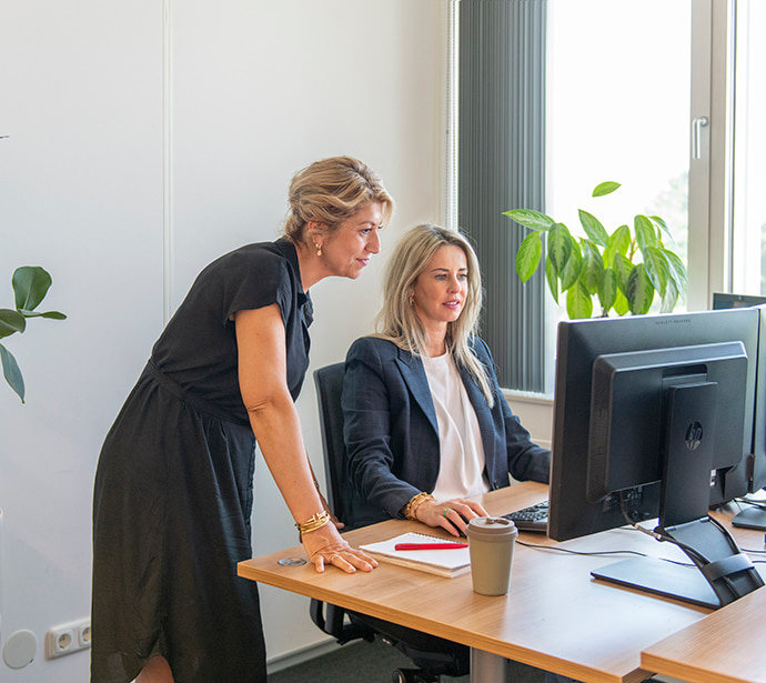 Beeld van medewerkers die zich buigen over een computerscherm